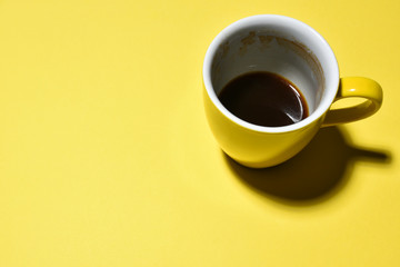 yellow half drinked cup of coffee on paper background