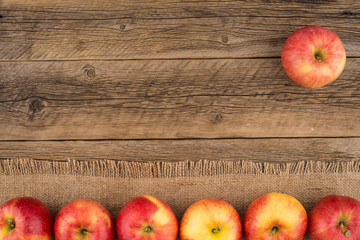 Red apples on the old wooden table.