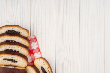 Bun with poppy seeds on a kitchen napkin and an old wooden table.