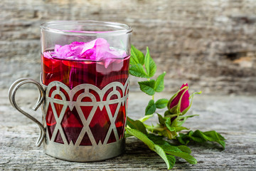 Cup of tea with rose petals, hot drink for autumn cold and flu