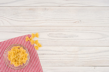 Pasta in a glass bowl on the old wooden table.