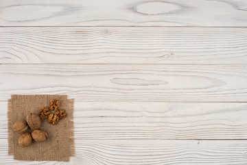 Walnuts on old white wooden table.