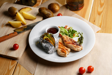 Grilled chicken fillets, chili pepper and tomatoes cherry. baked potatoes in foil