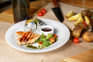 Grilled chicken fillets, chili pepper and tomatoes cherry. baked potatoes in foil
