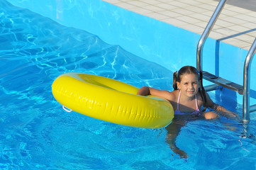 Adorable toddler relaxing in swimming pool