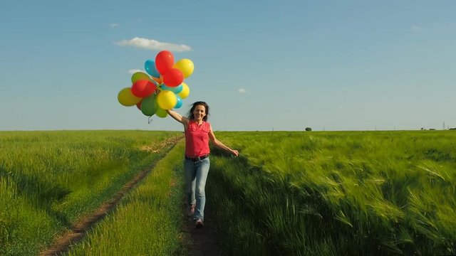 Happy girl with balloons on nature. The girl is running with balloons.