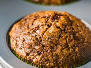 Banana chocolate muffins with caramel sugar topping on dark background