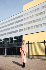 Serious young blonde lady walking outdoors. Looking aside.