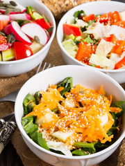 Colorful vegetable salad bowl for lunch on wooden rustic background