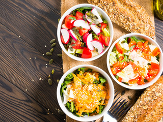 Colorful vegetable salad bowl for lunch on wooden rustic background
