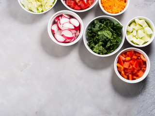 Mix of vegetable bowls for salad or snacks on gray background. Diet detox concept