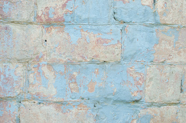 An old concrete wall with peeling blue paint. Vintage texture.