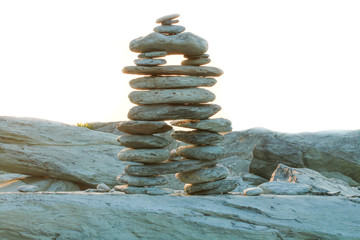Fototapeta na wymiar Zen rock balancing statue built with natural rocks near the ocean. Shot at sunrise
