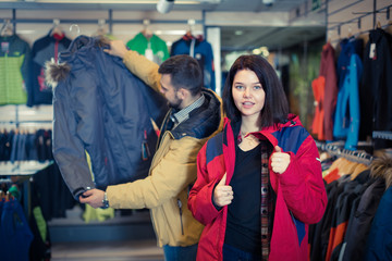 Young woman deciding on windcheater in store