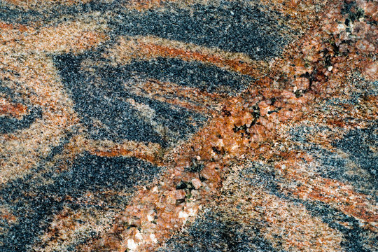 Textured surface with numerous polished pebbles of different colors.