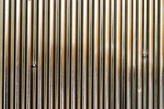 Brilliant metal surface with vertical lines, with scratches.