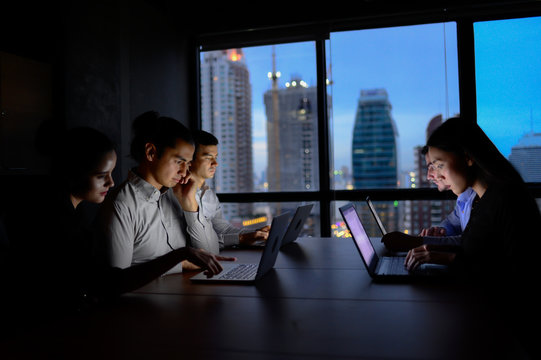 business team working with computer overtime at night and low light