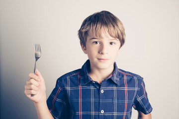 little boy with fork ready to eat - filtered retro style