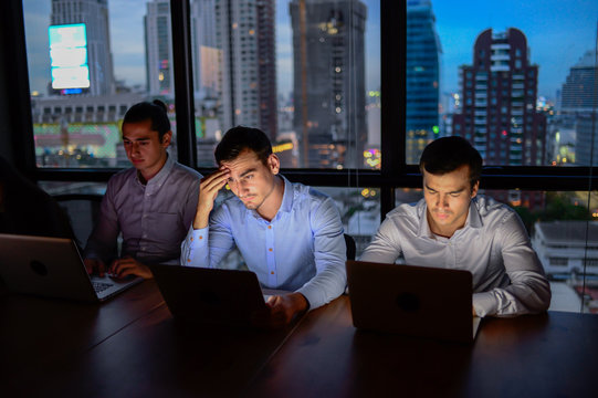 business team, three man working with computer overtime at night and low light