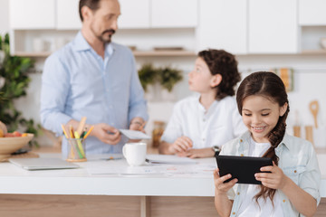 Charming little girl watching a video on the tablet