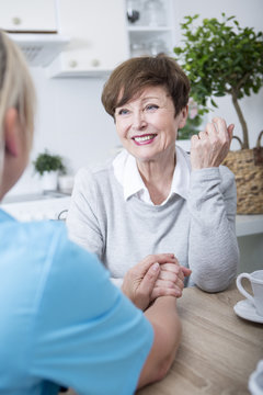Geriatric nurse listening to elderly patient