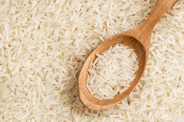 Close up of parboiled rice background with wooden spoon. Top view, high resolution product. Healthy food concept