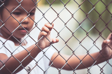 Child little girl hand holding steel mesh in vintage color tone