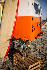 bus with a surfboard on the roof is a parked near the beach