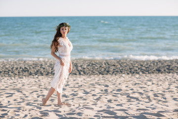 Beautiful girl on the beach in a beautiful dress. Sunny day, white sand, boho