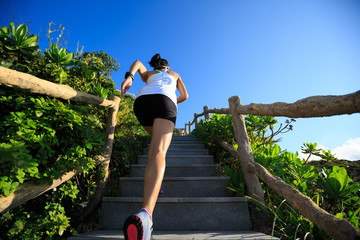 young fitness woman runner running upstairs on mountain stairs