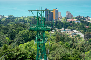 Fototapeta premium Cableway in Sochi Arboretum against the sea. Building of circus on background