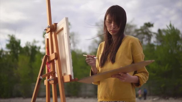 Woman painter working en plein air. She painting from nature in impressionism art style