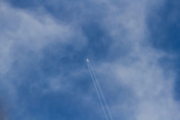 Avion entre Nubes dejando Rastro en el Cielo