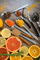 the fragrance of spices, red pepper, black pepper, mustard,sunflower seeds ,and orange slices of citrus fruits on dark wooden background of the table.