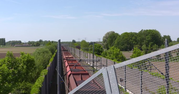 Iron ore train on the Betuweroute track near Groessen - hig angle. The Betuweroute is a double track freight railway, lined with concrete walls and roll bars along the track from Rotterdam to Germany