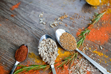the fragrance of spices, red pepper, black pepper, mustard,sunflower seeds ,and orange slices of citrus fruits on dark wooden background of the table.