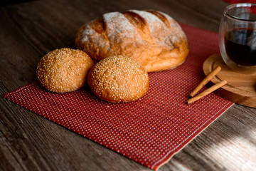 Fresh bread and coffee on wooden table.