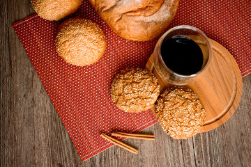 Fresh bread, cookies and coffee on wooden table.