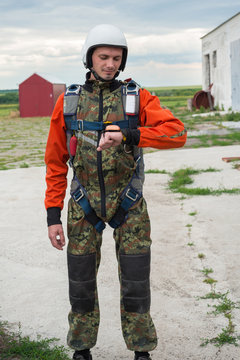 Skydiver stands on the airfield and checks his gear