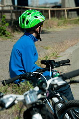 The bicyclist sits near the road