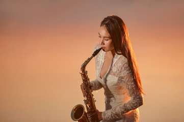 Asian woman jazz musician with saxophone in the field,vintage style