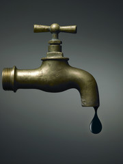 Old faucet with the last oil drop, abstract on dramatic background