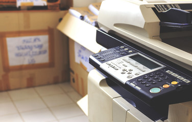 multifunction printer in office with soft-focus and over light in the background