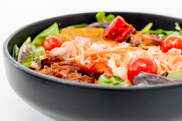 Delicious fresh salad with tomatoes, lettuce, eggplant, zucchini, cheese, parma ham and olive oil.