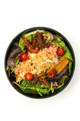 Delicious fresh salad with tomatoes, lettuce, eggplant, zucchini, cheese, parma ham and olive oil.