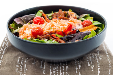 Delicious fresh salad with tomatoes, lettuce, eggplant, zucchini, cheese, parma ham and olive oil.