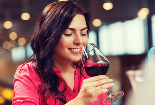 Smiling Woman Drinking Red Wine At Restaurant