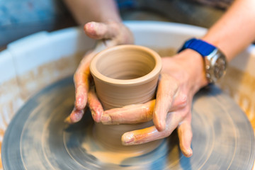 Fototapeta na wymiar Pottering - creating a clay cup in process