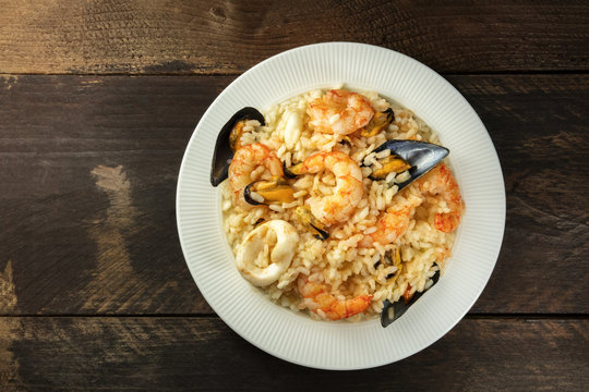 Seafood risotto on dark rustic background with copyspace