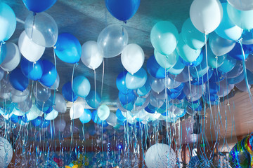 Festive decorated selling with blue tone helium balloons, birthday party